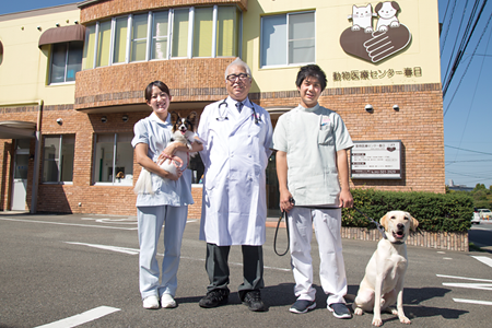 病院の前で佐藤院長、谷口さんとワンちゃんたち