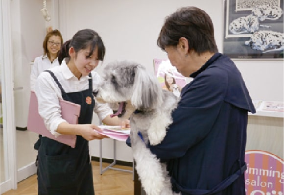 ワンちゃんの仕上がりを飼い主様に説明する学生